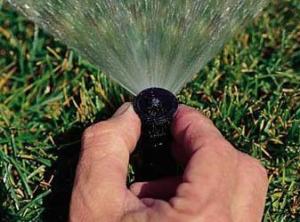 a irrigation repair in Burke technician adjusts a poorly aimed pop up head